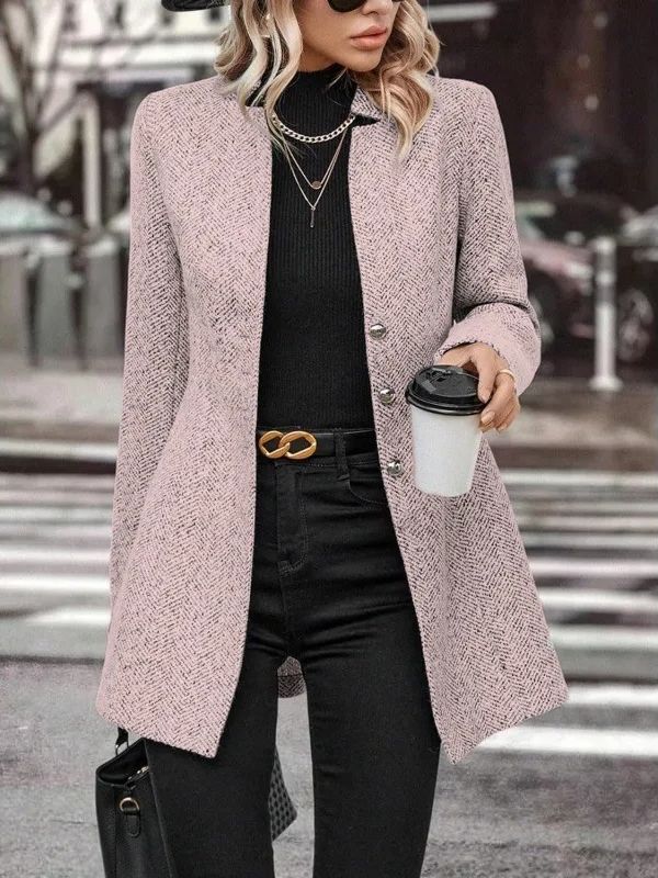 Donna con cappotto rosa elegante, maglione nero e pantaloni scuri, tiene un caffè da asporto. Moda autunnale, stile urbano chic.