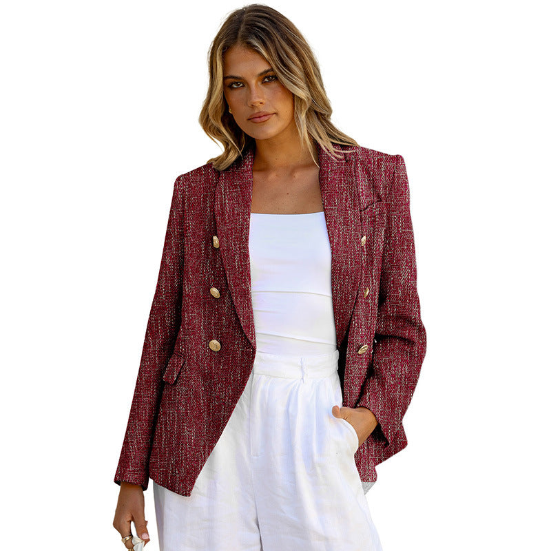 Donna con blazer rosso a doppio petto, bottoni dorati, indossa top bianco e pantaloni bianchi. Moda elegante, abbigliamento femminile chic.
