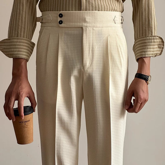 Uomo in camicia a righe e pantaloni eleganti bianchi, tiene un bicchiere di caffè. Moda maschile, abbigliamento formale, stile contemporaneo.