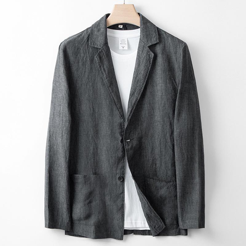 Giacca blazer grigia in lino su appendiabiti, con t-shirt bianca sotto. Moda uomo elegante, abbigliamento casual chic, tessuto leggero.
