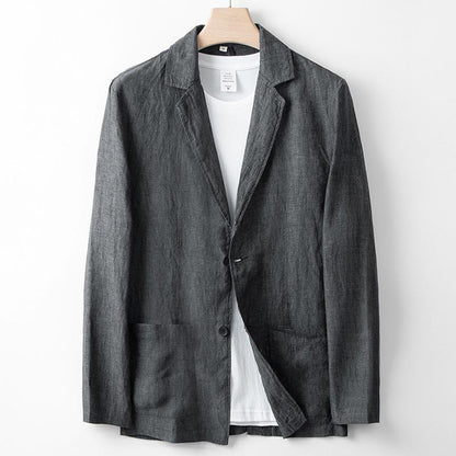 Giacca blazer grigia in lino su appendiabiti, con t-shirt bianca sotto. Moda uomo elegante, abbigliamento casual chic, tessuto leggero.