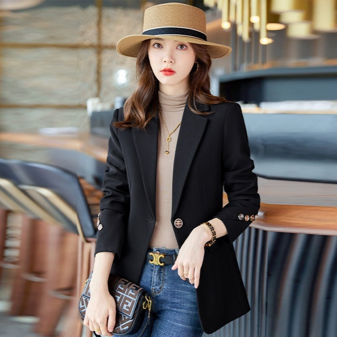 Donna elegante con cappello di paglia, blazer nero e jeans, in un moderno caffè. Moda femminile, stile casual chic, accessori di tendenza.