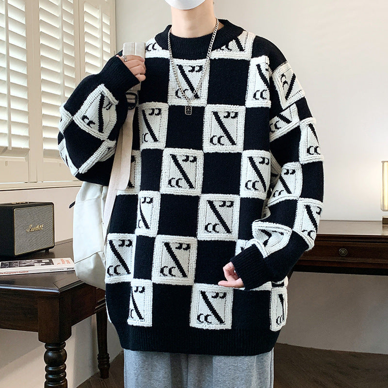 Maglione oversize nero e bianco con motivo geometrico a quadri, indossato da una persona in una stanza moderna. Stile casual, moda autunno inverno.