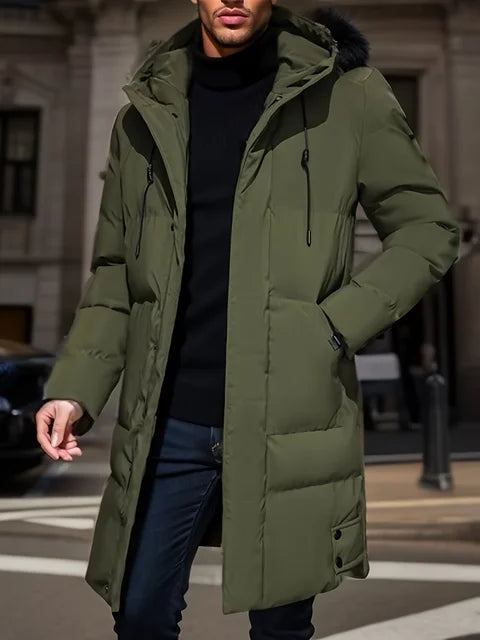 Uomo con cappotto invernale verde oliva, lungo e imbottito, cammina in città. Moda maschile, abbigliamento caldo, stile urbano.