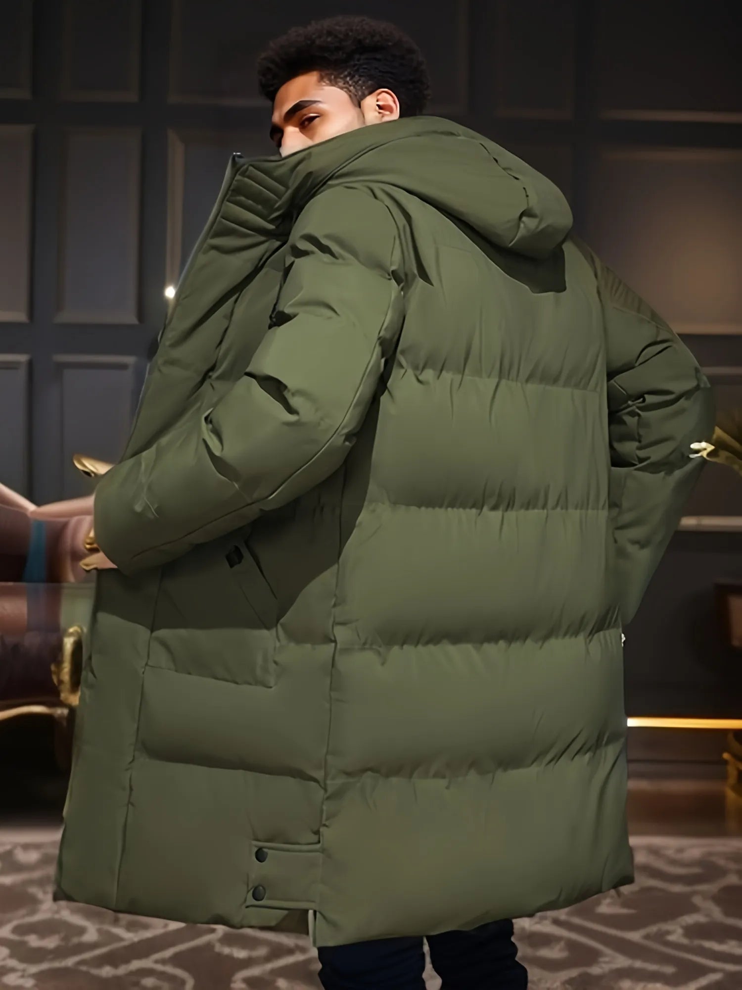 Giacca invernale verde oliva, imbottita e con cappuccio, indossata da una persona in un ambiente interno elegante. Moda uomo, cappotto caldo.