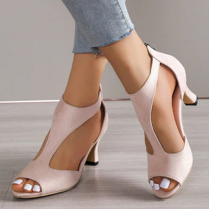 Sandali rosa con tacco medio, design aperto, indossati con jeans chiari. Scarpe eleganti da donna, ideali per moda estiva e look casual chic.