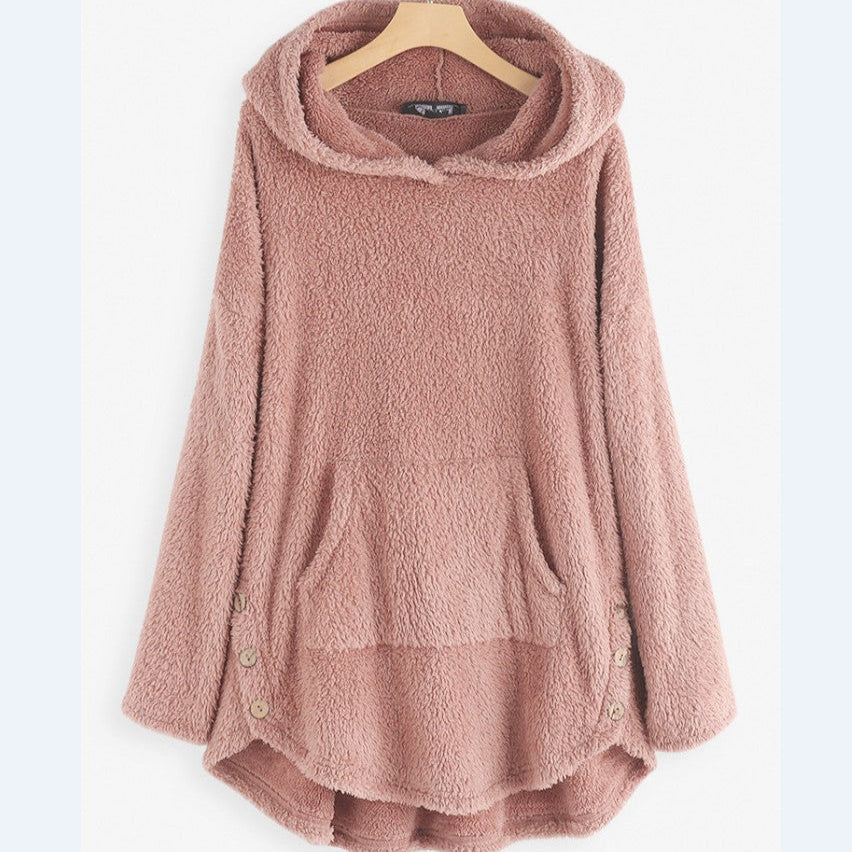 Maglione oversize in pile rosa con cappuccio, tasche frontali e bottoni decorativi, appeso su gruccia. Morbido e caldo, ideale per l'inverno.