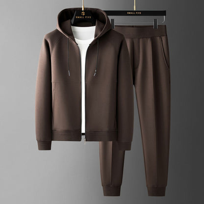 Completo tuta marrone con felpa con cappuccio e pantaloni, appeso su grucce. Abbigliamento casual uomo, moda autunno, tessuto morbido.