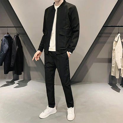 Uomo in abbigliamento casual nero, giacca e pantaloni, in negozio di moda moderna. Scarpe bianche, sfondo con abiti appesi.