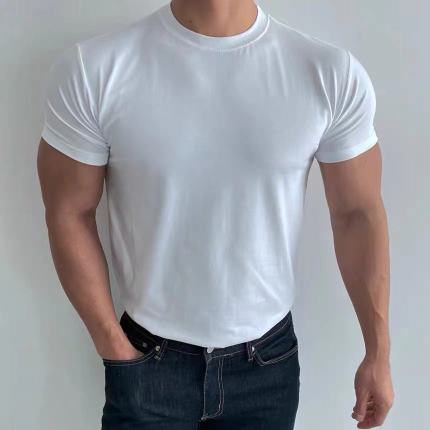 Uomo in t-shirt bianca aderente e jeans scuri, posa casuale. Moda maschile, abbigliamento casual, stile moderno.