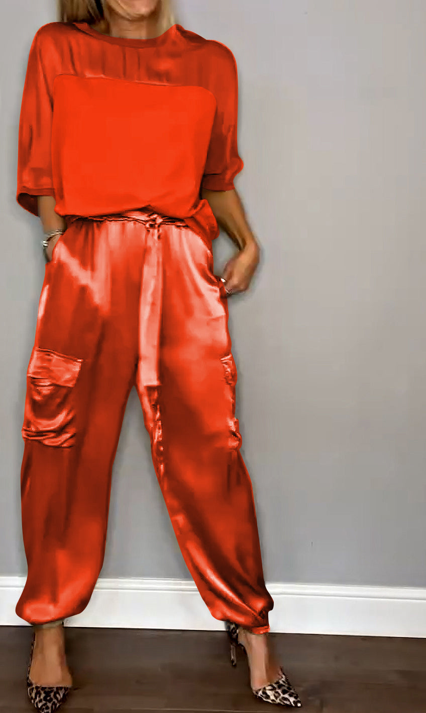 Donna in abbigliamento elegante, indossa blusa e pantaloni di seta rossi, scarpe leopardate. Moda femminile, stile sofisticato, tendenze 2023.