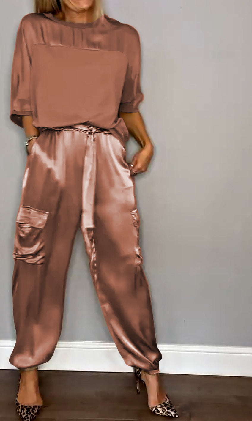 Donna in abbigliamento elegante: blusa e pantaloni satinati color bronzo, scarpe leopardate. Moda femminile, stile sofisticato, tendenze 2023.