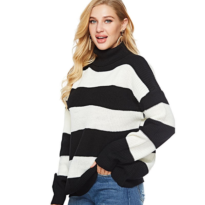 Donna con maglione a righe bianche e nere, collo alto, maniche lunghe, indossa jeans. Moda autunnale, look casual chic, tendenze abbigliamento.