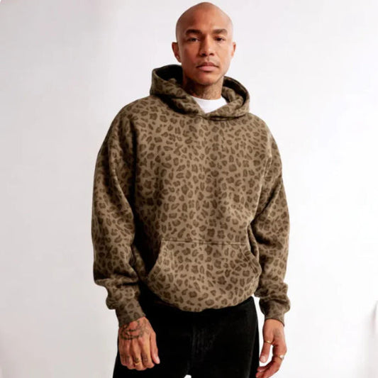Uomo con felpa con cappuccio leopardata marrone, moda casual, sfondo bianco. Stile urbano, abbigliamento autunnale, tendenze moda uomo.