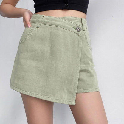 Gonna corta asimmetrica verde chiaro in denim, indossata con top nero. Moda estiva casual, stile giovanile e trendy.
