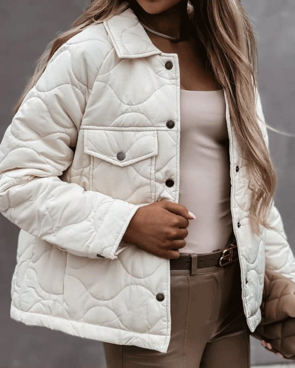 Giacca trapuntata bianca da donna, stile casual, con bottoni scuri e tasca frontale. Moda autunnale, abbigliamento femminile elegante.