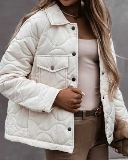 Giacca trapuntata bianca da donna, stile casual, con bottoni scuri e tasca frontale. Moda autunnale, abbigliamento femminile elegante.