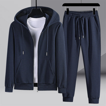 Tuta sportiva blu scuro con felpa con cappuccio e pantaloni, tessuto a coste, appesa su grucce. Abbigliamento casual uomo, moda autunno inverno.