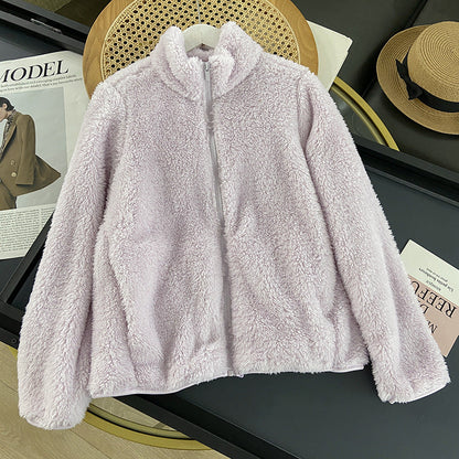 Giacca in pile morbido color lavanda su appendiabiti, sfondo con riviste di moda e cappello di paglia. Abbigliamento autunnale, moda femminile.