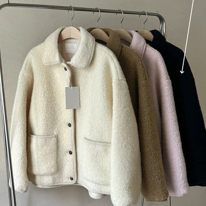 Quattro giacche in pile appese su un appendiabiti, colori: bianco, marrone, rosa, nero. Moda autunno inverno, abbigliamento caldo e confortevole.