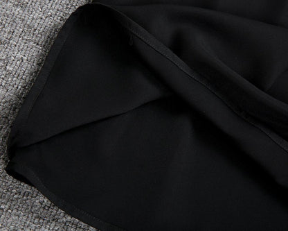 Tessuto nero su sfondo grigio, dettaglio di stoffa elegante e morbida. Materiale di alta qualità per abbigliamento o arredamento.