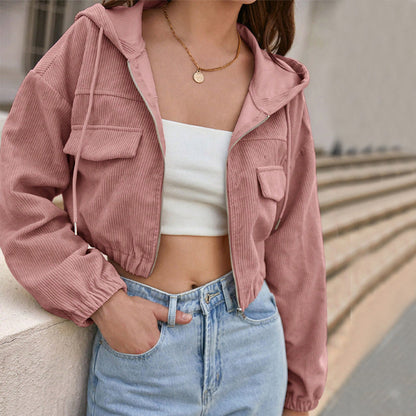 Giacca corta rosa in velluto a coste, indossata con top bianco e jeans a vita alta. Moda casual femminile, stile urbano trendy.