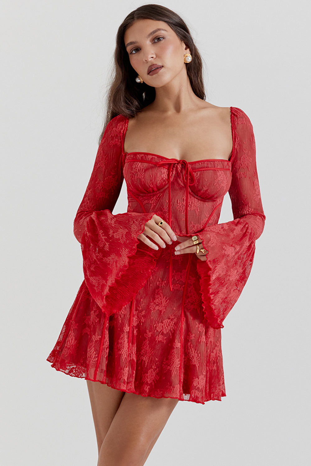 Donna con abito rosso elegante, maniche a campana, scollo quadrato, dettagli in pizzo. Moda femminile, stile sofisticato, tendenze abbigliamento.
