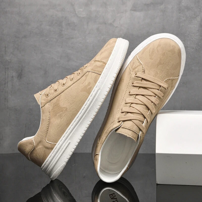 Scarpe da ginnastica beige su sfondo grigio, design moderno con suola bianca. Calzature casual eleganti, perfette per moda urbana e comfort quotidiano.