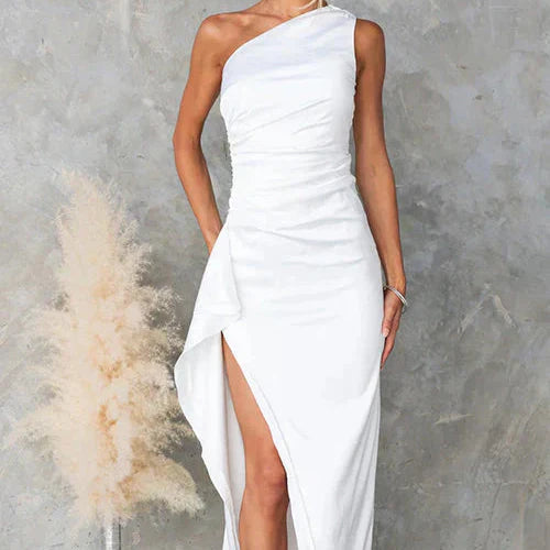 Abito da sera bianco monospalla con spacco laterale, elegante e moderno, su sfondo grigio. Perfetto per eventi formali e cerimonie.