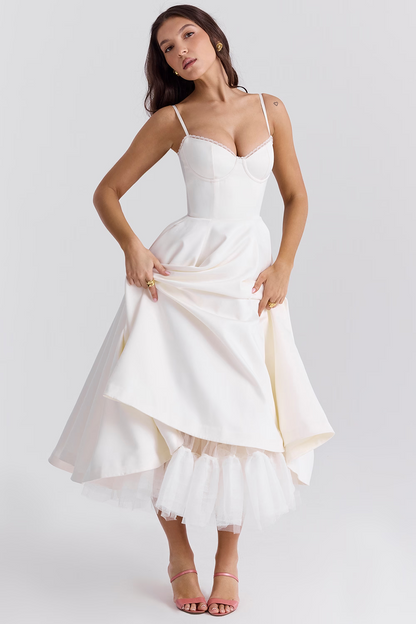 Donna in abito da sposa bianco elegante, con corpetto aderente e gonna ampia, posa su sfondo neutro. Vestito da cerimonia, moda nuziale.