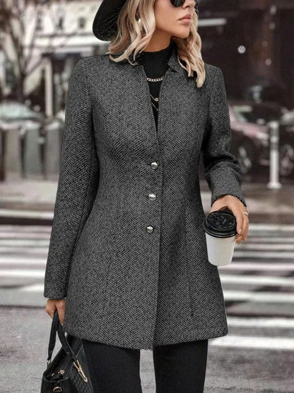 Donna con cappotto grigio elegante, cappello nero e occhiali da sole, tiene caffè da asporto e borsa. Moda autunnale in città.