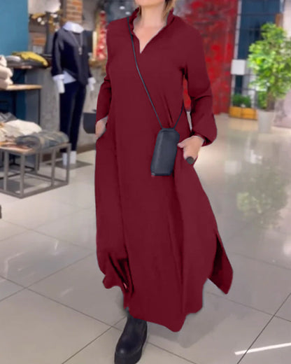 Donna in abito lungo rosso scuro, con borsa a tracolla nera, in negozio di moda. Scarpe nere, ambiente moderno, abbigliamento casual elegante.