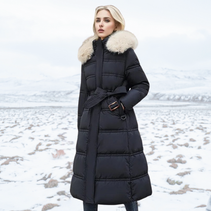 Donna in cappotto invernale nero con cappuccio in pelliccia, paesaggio innevato sullo sfondo. Moda inverno, abbigliamento caldo, stile elegante.