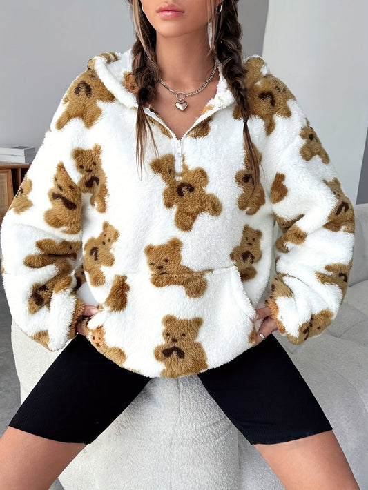 Donna con felpa bianca in pile con stampa orsacchiotti marroni, seduta su divano. Moda autunnale, abbigliamento casual, stile confortevole.