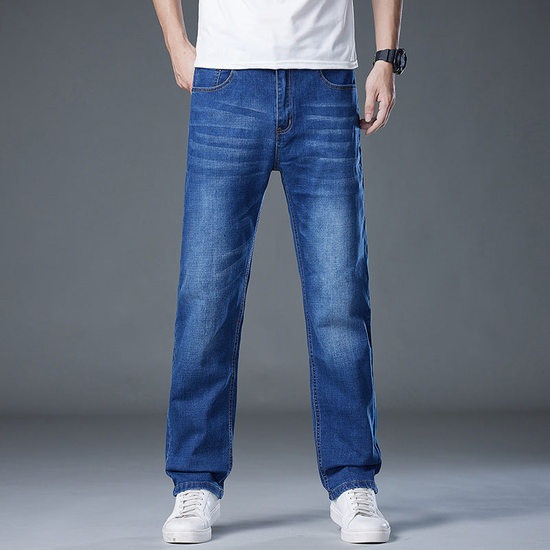 Jeans uomo blu, taglio dritto, indossati con t-shirt bianca e scarpe da ginnastica bianche. Moda casual maschile, abbigliamento denim.