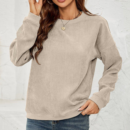 Donna con maglione beige a coste, maniche lunghe, indossa jeans e collana dorata. Moda casual autunnale, abbigliamento femminile trendy.