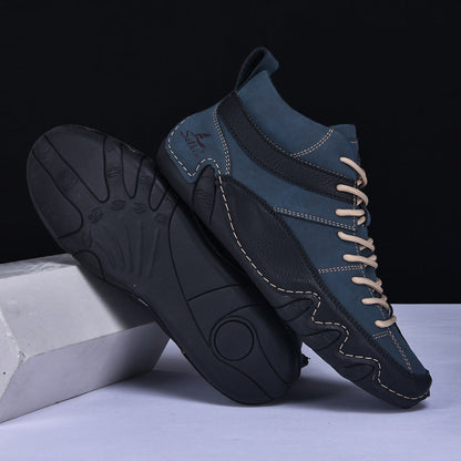 Scarpe da ginnastica alte blu e nere con suola in gomma nera, cuciture a contrasto e lacci beige, su sfondo nero. Design moderno e sportivo.