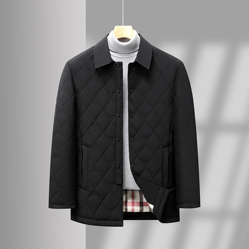Giacca trapuntata nera elegante appesa, con colletto classico e tasche, su sfondo grigio. Moda uomo, abbigliamento invernale, stile casual chic.