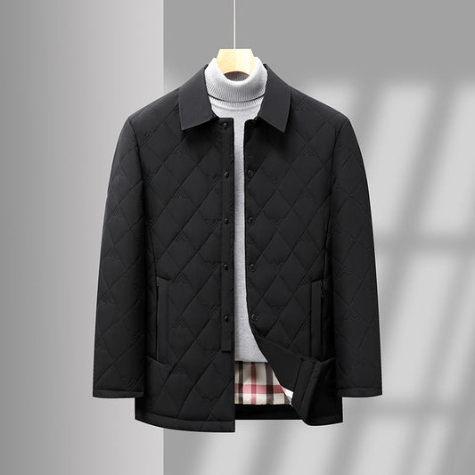 Giacca trapuntata nera elegante appesa, con colletto classico e tasche, su sfondo grigio. Moda uomo, abbigliamento invernale, stile casual chic.