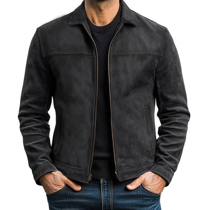 Giacca in pelle nera da uomo, stile casual, con zip frontale e tasche laterali, indossata su maglia scura e jeans. Moda maschile autunnale.