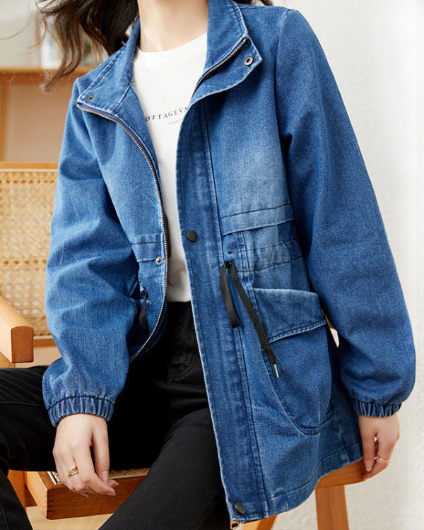 Giacca di jeans blu casual da donna con cerniera e tasche, indossata sopra una maglietta bianca. Stile moda autunnale, abbigliamento casual chic.
