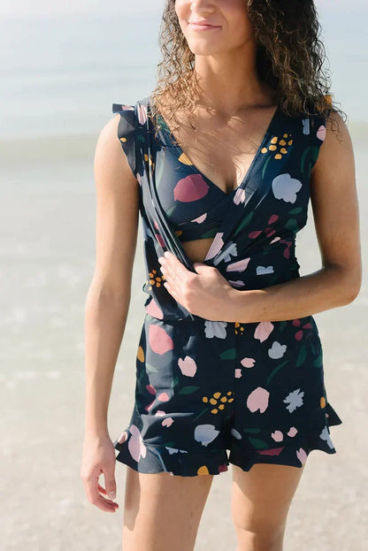 Donna in spiaggia con abito estivo floreale, sfondo mare. Moda estiva, abbigliamento donna, vestito floreale, look da spiaggia.