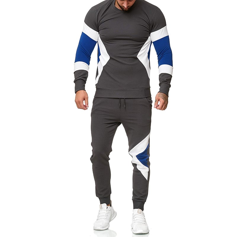 Tuta sportiva uomo grigia con dettagli blu e bianchi, design moderno, maniche lunghe, pantaloni con coulisse, perfetta per allenamento e tempo libero.