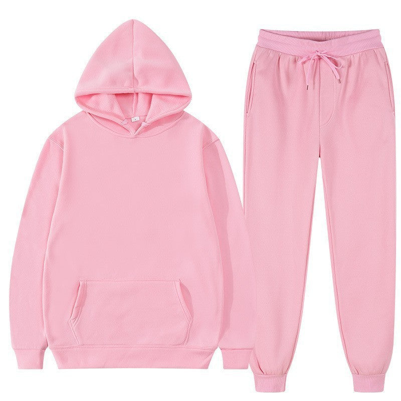 Tuta sportiva rosa in cotone, composta da felpa con cappuccio e pantaloni con coulisse. Abbigliamento casual unisex, moda comoda e trendy.