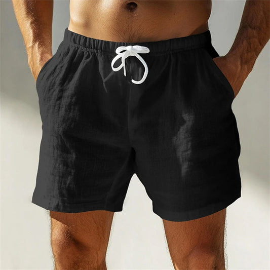 Uomo in pantaloncini neri da spiaggia con tasche, cordoncino bianco, tessuto leggero. Abbigliamento estivo maschile, moda casual.