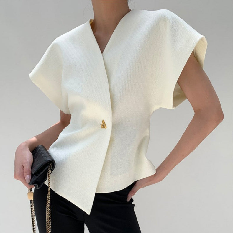 Donna con elegante top bianco asimmetrico, pantaloni neri e borsa a tracolla. Moda minimalista, abbigliamento chic, stile contemporaneo.