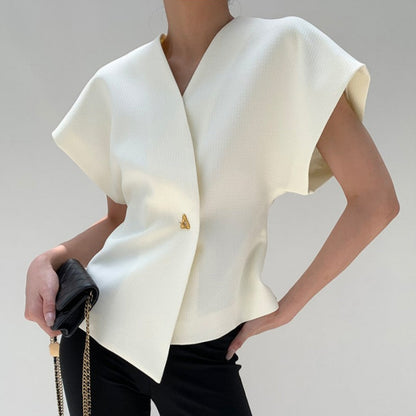 Donna con elegante top bianco asimmetrico, pantaloni neri e borsa a tracolla. Moda minimalista, abbigliamento chic, stile contemporaneo.