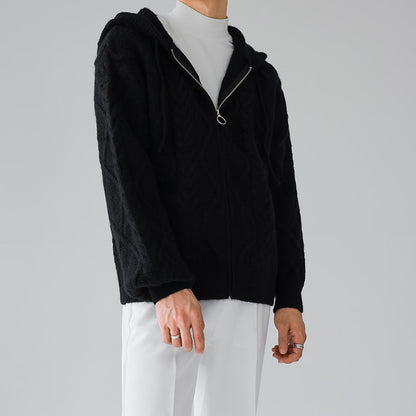 Uomo con felpa nera con cappuccio e zip, indossa pantaloni bianchi. Moda casual, abbigliamento autunnale, stile minimalista.