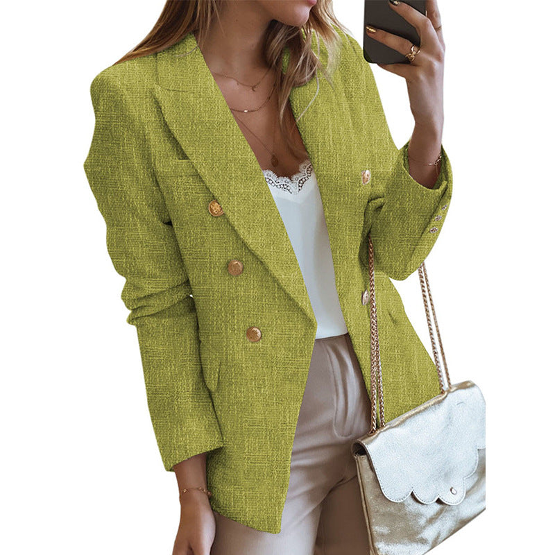 Donna con blazer verde lime, top bianco e pantaloni beige, tiene una borsa dorata. Moda elegante, abbigliamento femminile, stile casual chic.