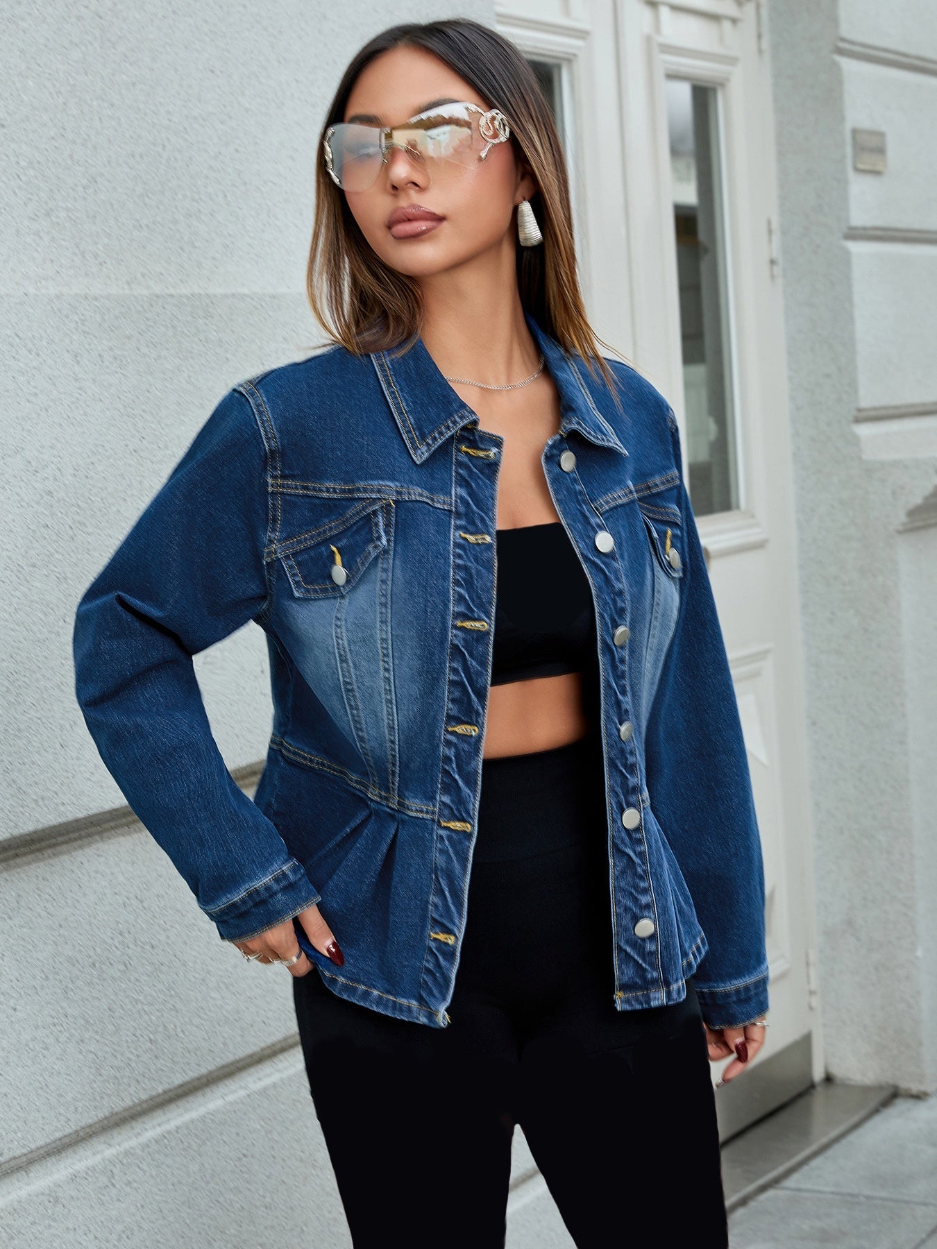 Donna con giacca di jeans blu, occhiali da sole specchiati e top nero. Moda urbana, stile casual chic, tendenze abbigliamento femminile.